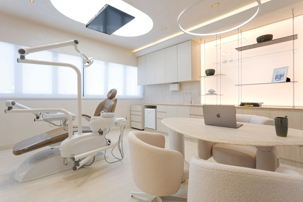 Consultório odontológico premium com iluminação quente e mobiliário claro